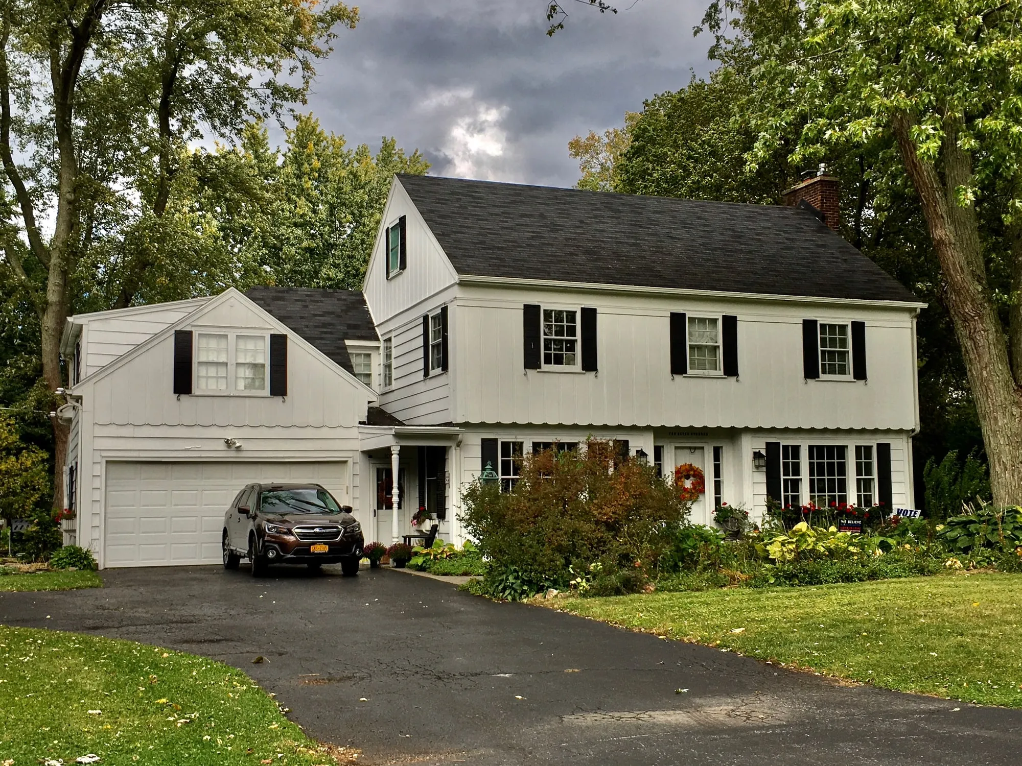 A white two-story house with black shutters, as photographed